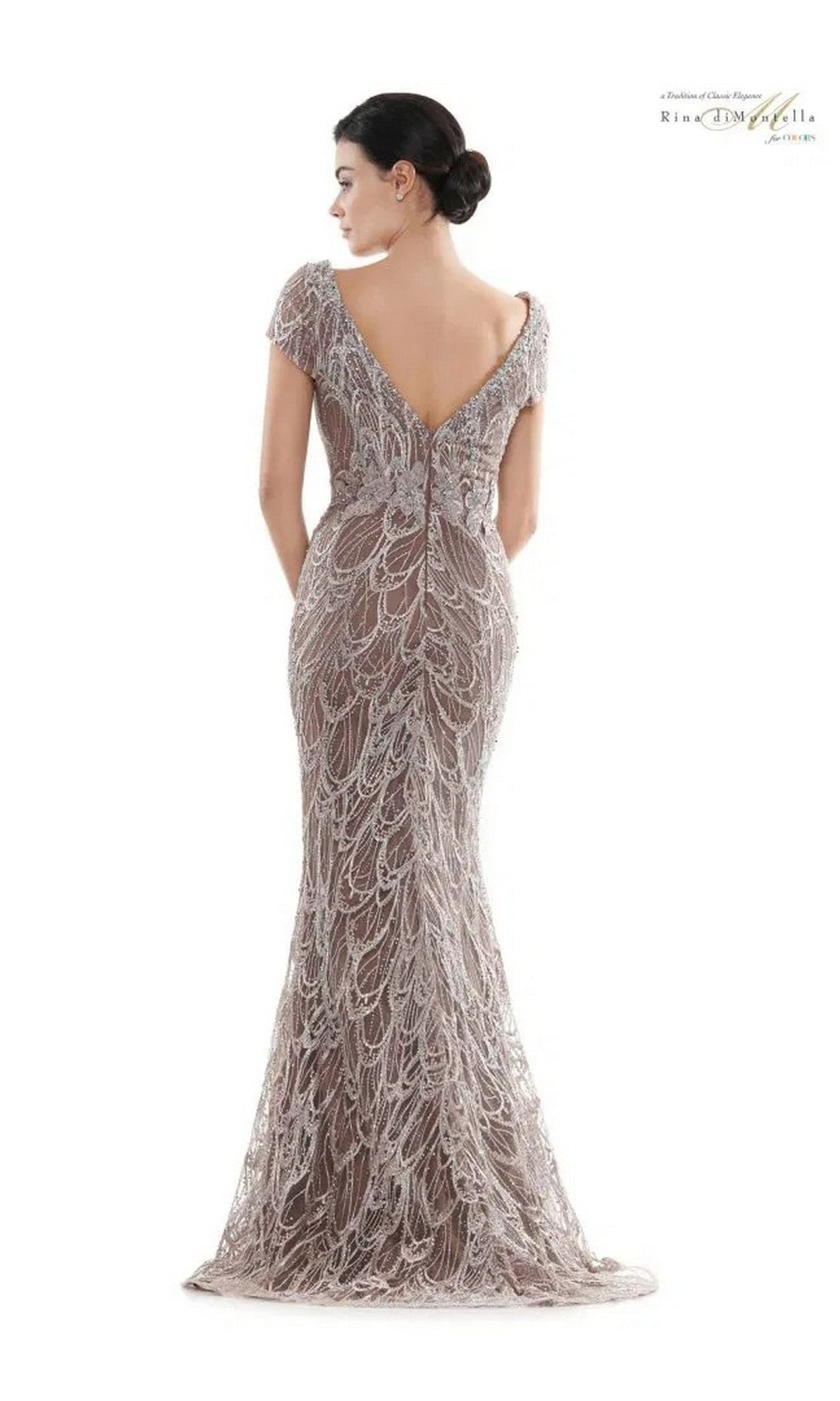 Woman wearing the Rina Di Montella RD2716 long formal dress—this fitted lace gown features a low V-back, cap sleeves, and a graceful mermaid silhouette, ideal for anyone seeking an elegant embroidered evening look.